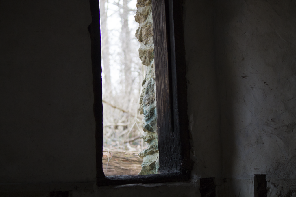 A view looking out an old window at Lindner Park